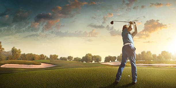 golfe: homem jogando golfe em um campo de golfe - golf golf flag sunset flag - fotografias e filmes do acervo