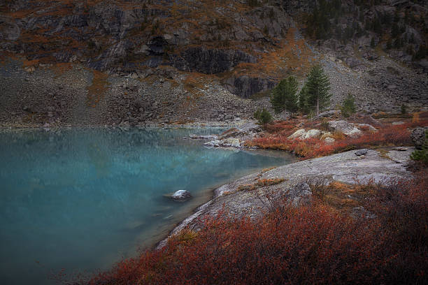 istock Blue Muddy Mountain Lake WIth Red Color Growth On The 636531314