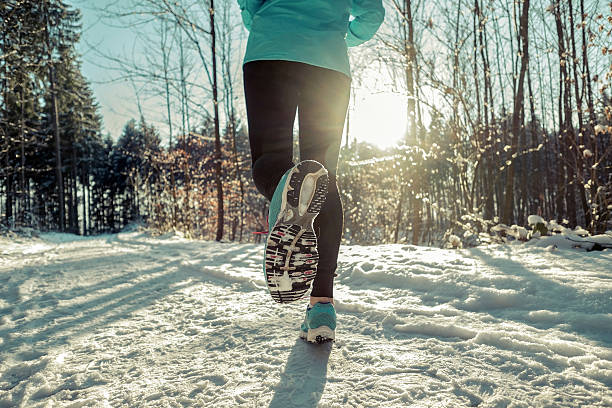 istock Woman Running at snowly winter under sunlight. 636532494