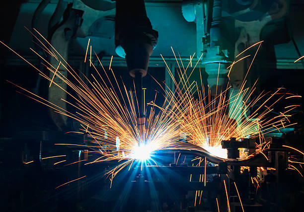 istock Team robots are welding in factory 636533420