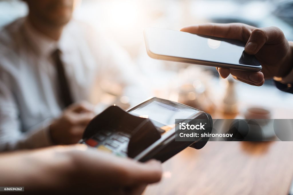 Nfc payment Buyer with smartphone paying through terminal Mobile Payment Stock Photo