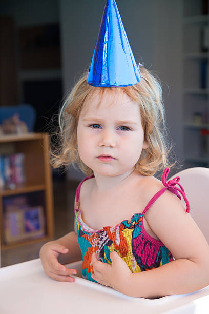 istock tired face child sitting with party hat 636534932