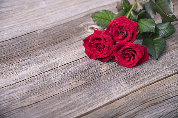 istock Red roses on a wooden boards. 636535886
