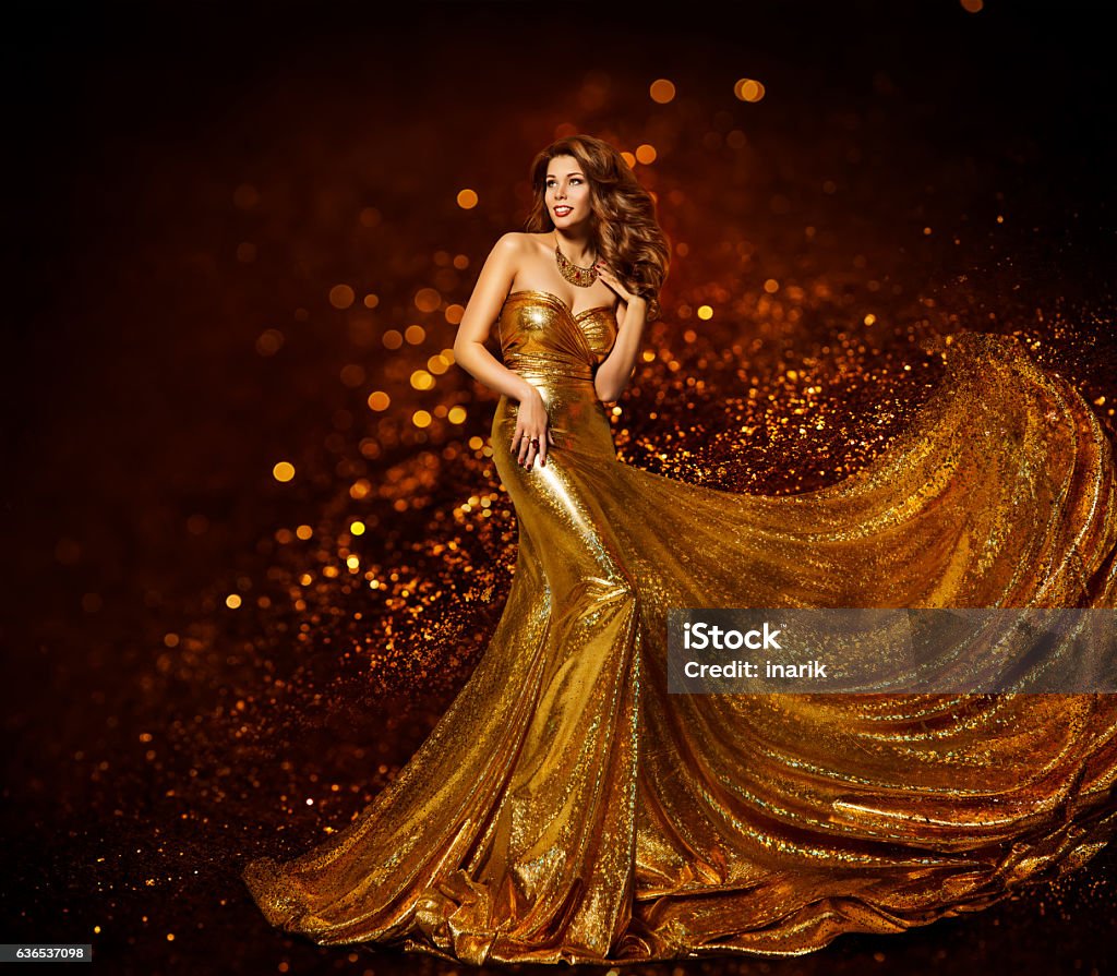 Fashion Woman Gold Dress, Girl Elegant Golden Fabric Gown Fashion Woman Gold Dress, Luxury Girl in Elegant Golden Fabric Gown, Flying Sparkles Cloth Gold Colored Stock Photo