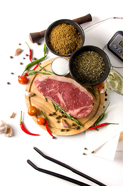 istock raw steak cutting board spices top view 636554008
