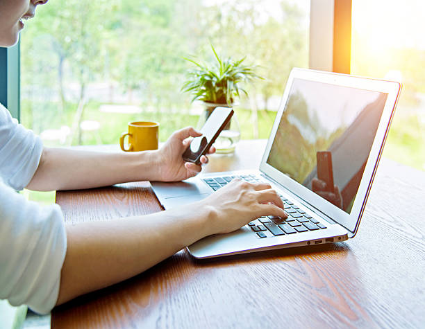 istock Woman using phone and laptop 636558692