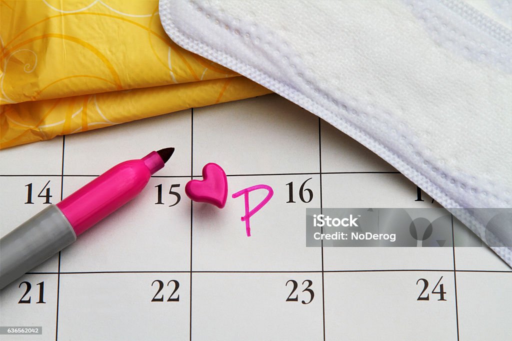 Menstruation concept: Calendar with women's personal hygiene items Calendar with date marked with heart push pin and letter P. Menstruation concept. Women's personal hygiene items: pads and liners.   Creative content brief 683313911. Menstruation Stock Photo