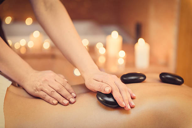 Masseuse massaging human body at spa