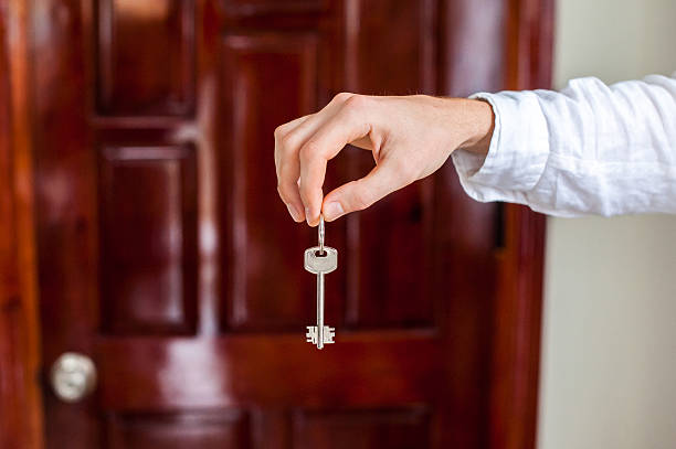 istock Men's hands hold house key on a background of 636566042