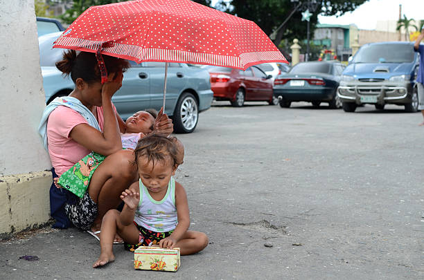 A mother with her children in a slum area near a railway in Jakarta, Indonesia, highlighting the urban poverty on October 31, 2016.