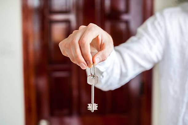 istock Men's hands hold house key on a background of 636566096
