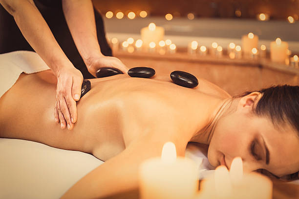 istock Professional beautician massaging female back by stones 636566118
