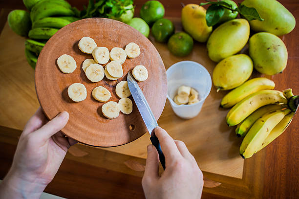 istock Sliced banana on cutting board Women's hands are placed in 636567960