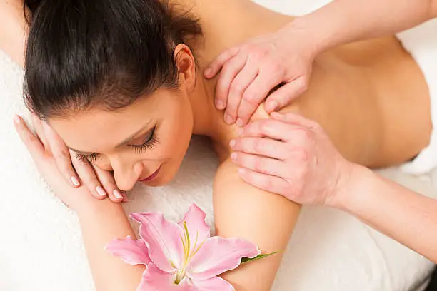 Beautifulyoung woman having a rejuvenating massage in a wellness studio - spa