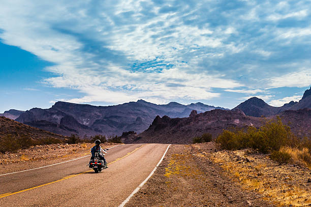 Biker driving on on legendary Route 66 to Oatman, Arizona. Oatman, Arizona, USA - September 10, 2015: Biker driving on the Highway on legendary Route 66 to Oatman, Arizona. number 66 stock pictures, royalty-free photos & images