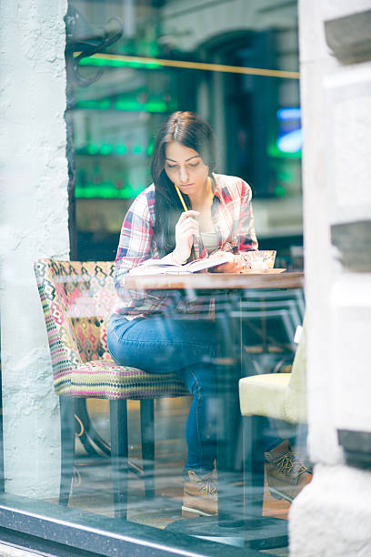 istock Cute, urban girl sitting in cafe, reading book 636571404