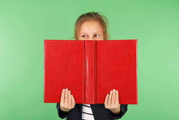 istock Young school girl with red book 636571974
