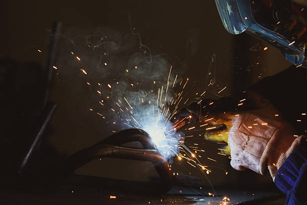 istock Welder working a welding metal with protective mask and sparks 636572928