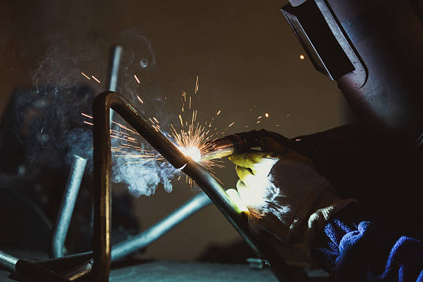 istock Welder working a welding metal with protective mask and sparks 636572956