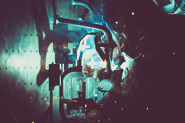 istock Metal welding by man wearing protective mask in a actory 636573968
