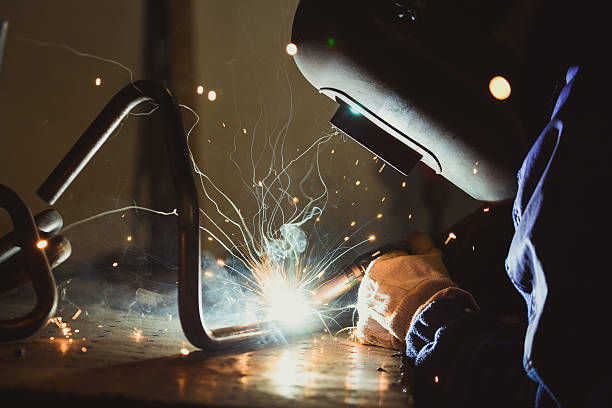 istock Industrial workshop welding pipe, smoke, yellow sparks 636573978