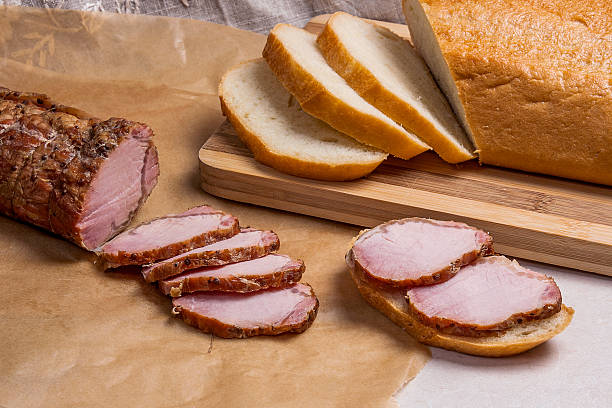 istock Slices smoked meat or ham on brown packing paper. 636574876