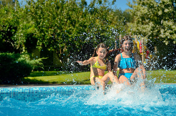 istock Kids in swimming pool have fun and splash in water 636575478
