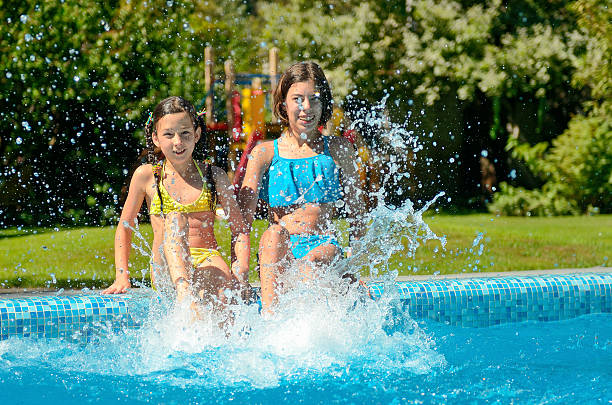 istock Kids in swimming pool have fun and splash in water 636577196