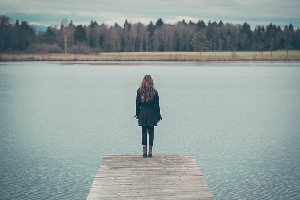 istock Young woman on a jetty at a lake in Austria 636577330