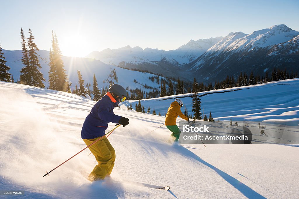 Couple skiing on a sunny powder day Skiing Stock Photo