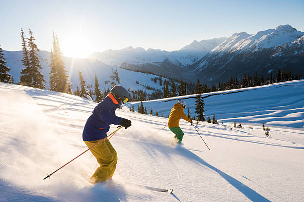 couple skiing on a sunny powder day - estância de esqui imagens e fotografias de stock