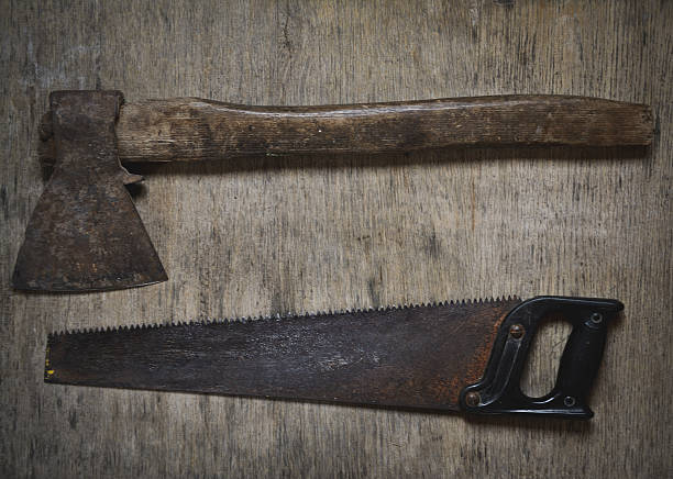 istock Old tools ax, saw, old tools on a wooden floor. 636581912