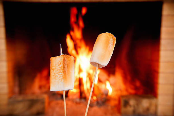 istock Two marshmallows on sticks being roasted by the fire 636582406