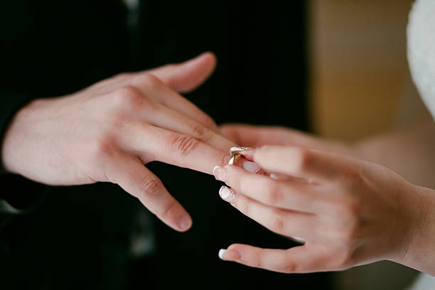 istock Bride wearing the Wedding Ring on groom. She Put the 636584770