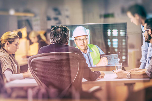 istock Architects listening to construction progress report on video 636585830