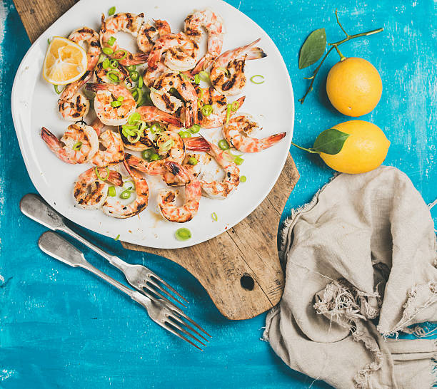 istock Grilled tiger prawns in white plate with lemon, leek, chili 636594668