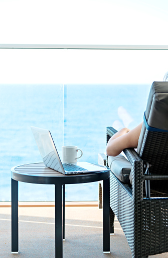Woman working with a laptop on cruise ship.