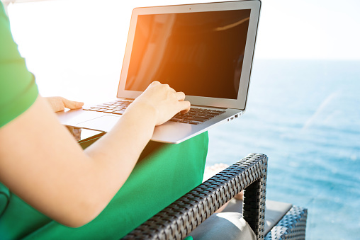 Woman working with a laptop on cruise ship.