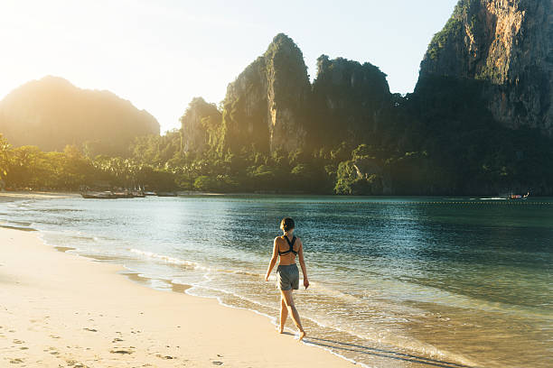 mulher caminhando na praia  - railay - fotografias e filmes do acervo