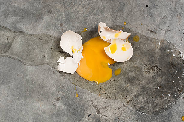 яйцо падает и ломаются на бетонном полу - unfinish стоковые фото и изображения