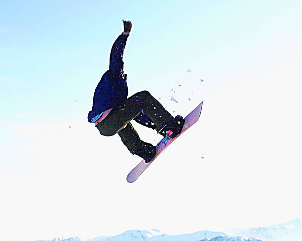 istock Male snowboarder jumping off cliff edge 636599604
