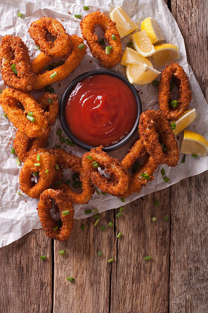 istock Squid rings fried in breadcrumbs and tomato sauce closeup 636600286