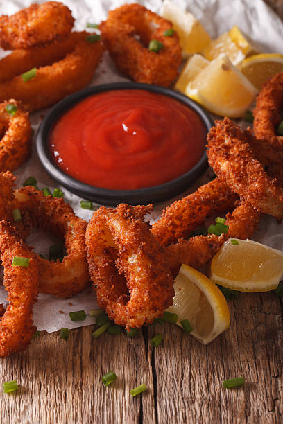 istock crunchy fried squid rings with ketchup and lemon close-up. vertical 636600492