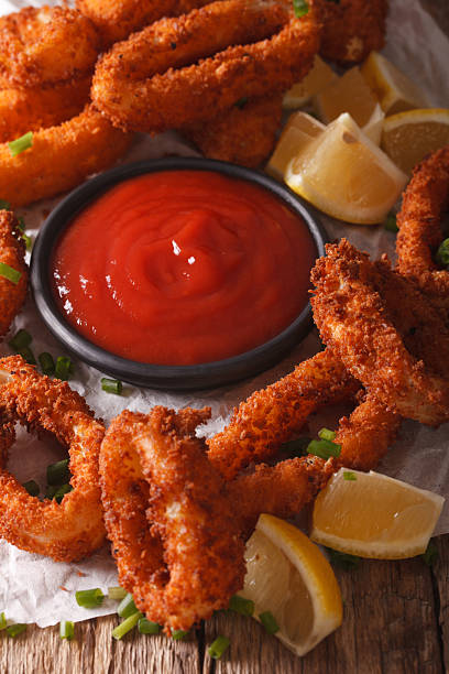 istock crispy fried squid rings with ketchup and lemon close-up. vertical 636600530