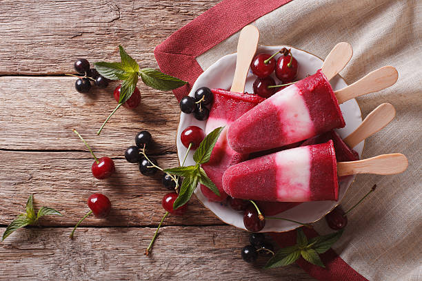 istock Popsicle with cherry on a stick close-up on the table 636602340