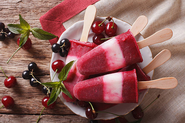 istock Fruit ice cream with cherry and currants on stick closeup 636602396