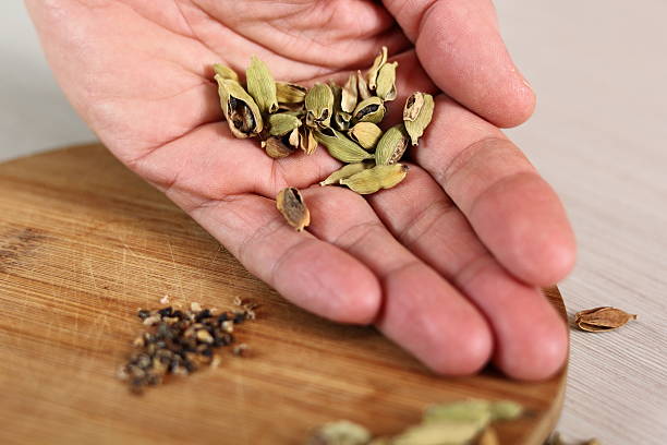 istock Cardamom pods and seeds on hand 636602456