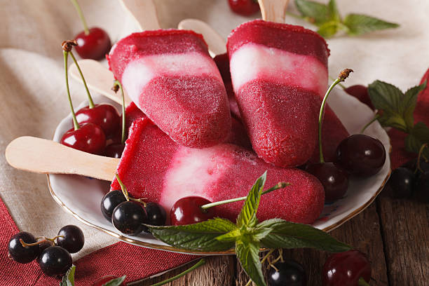 istock Popsicle with mint and cherry on a stick close-up 636602712