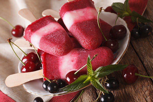 istock Fruit ice cream with cherry and currants on stick closeup 636602798