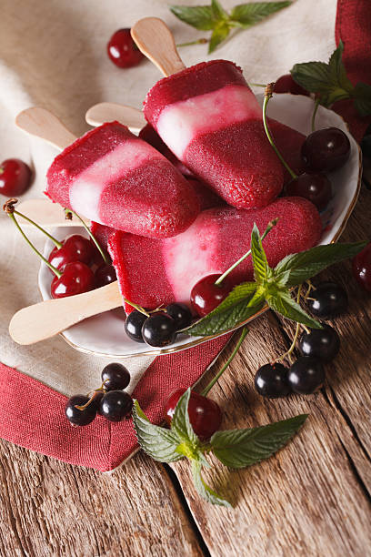 istock Fruit ice cream with cherry and currants on stick closeup 636602844